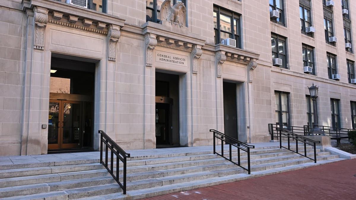 Stone entrance of the General Services Administration headquarters in Washington, with the agency name carved above the central door and granite steps below