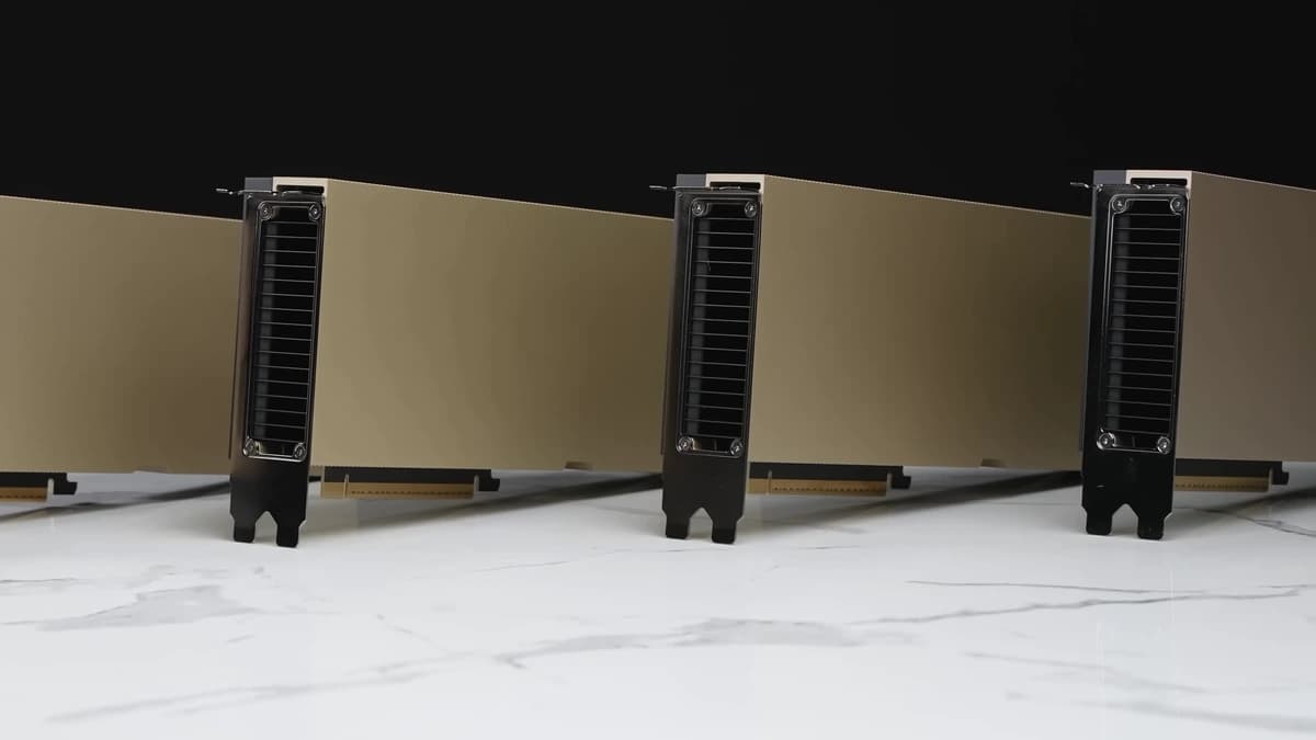 Row of gold-coloured NVIDIA H100 PCIe accelerator cards standing on a white marble surface against a black background