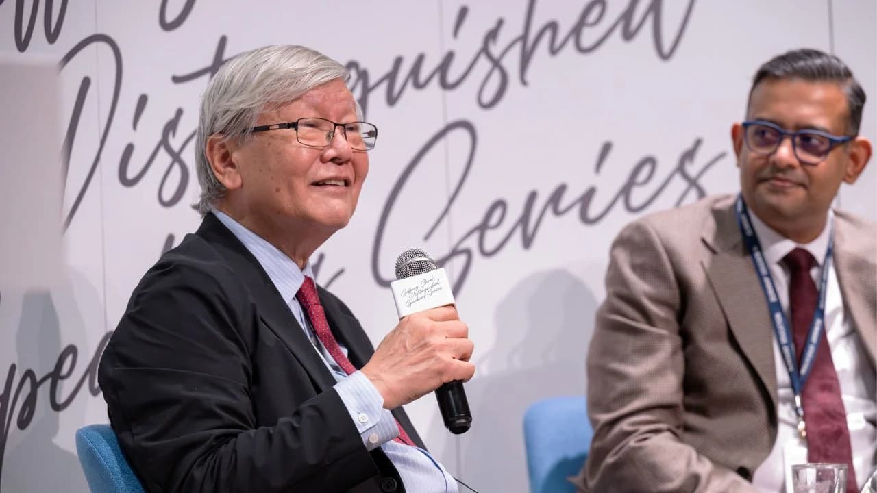 A speaker holds a microphone on stage beside a moderator at the Jeffrey Cheah Distinguished Speaker Series