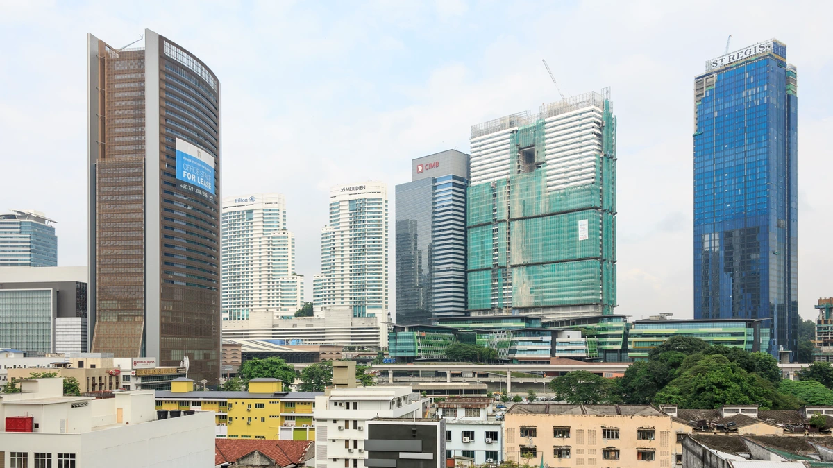 Office and hotel towers rise above low rooftops at KL Sentral in Kuala Lumpur, including a glass tower marked St. Regis