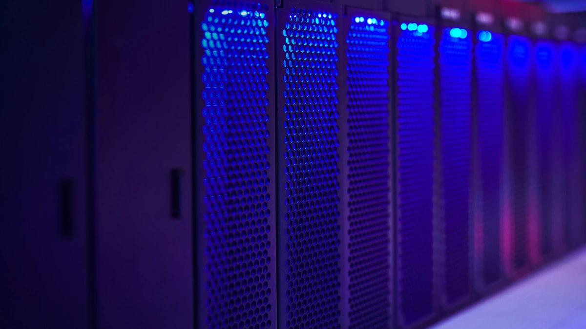 Rows of dark server racks with blue indicator lights in a data centre