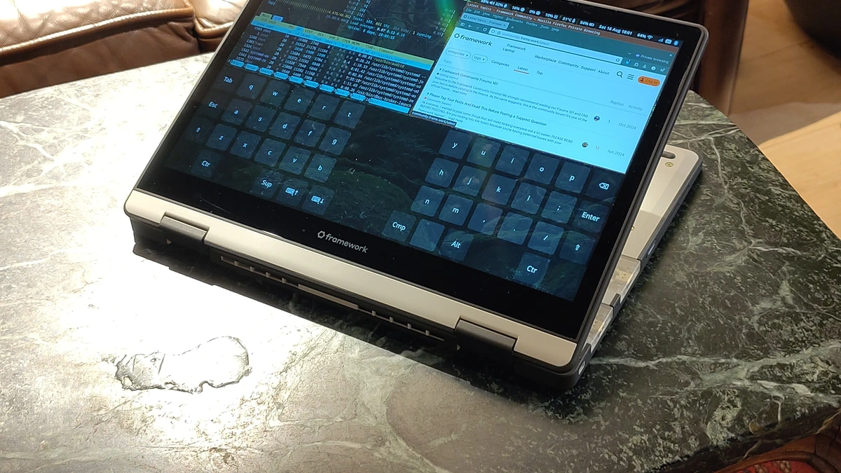 A Framework Laptop 12 displaying a Firefox desktop and system monitor