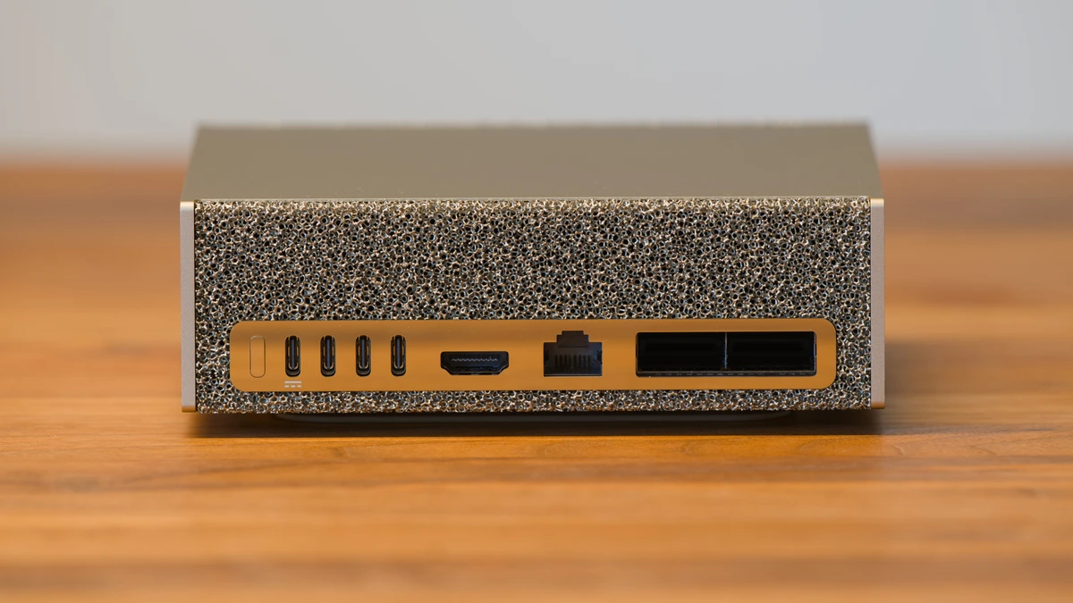 The rear panel of a small desktop computer showing four USB-C ports, an HDMI port, an Ethernet jack and two wide network sockets