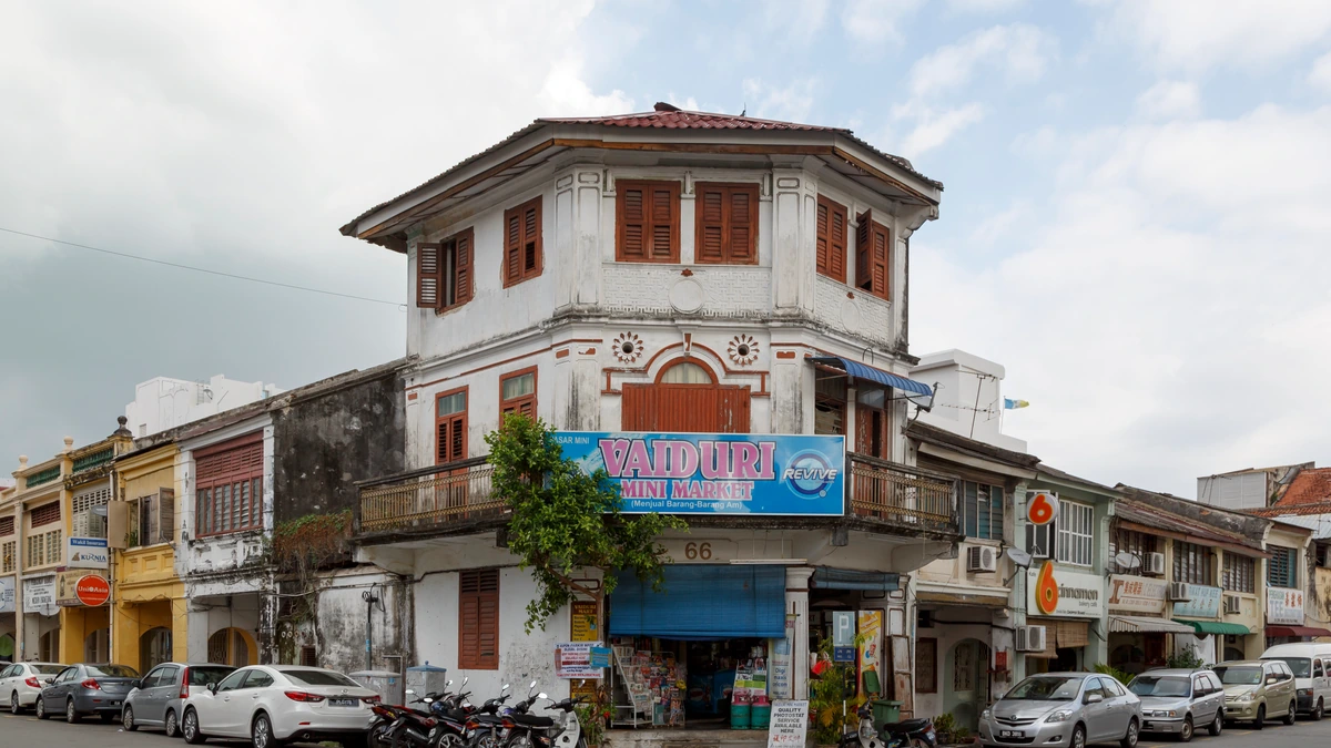 Corner mini market in George Town, Penang, with a blue sign and motorcycles outside