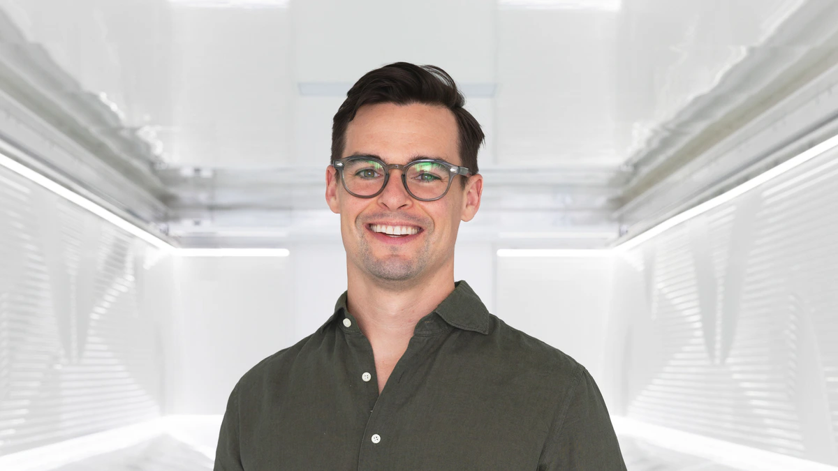 Firmus co-founder and co-chief executive Tim Rosenfield standing inside a white immersion cooling enclosure