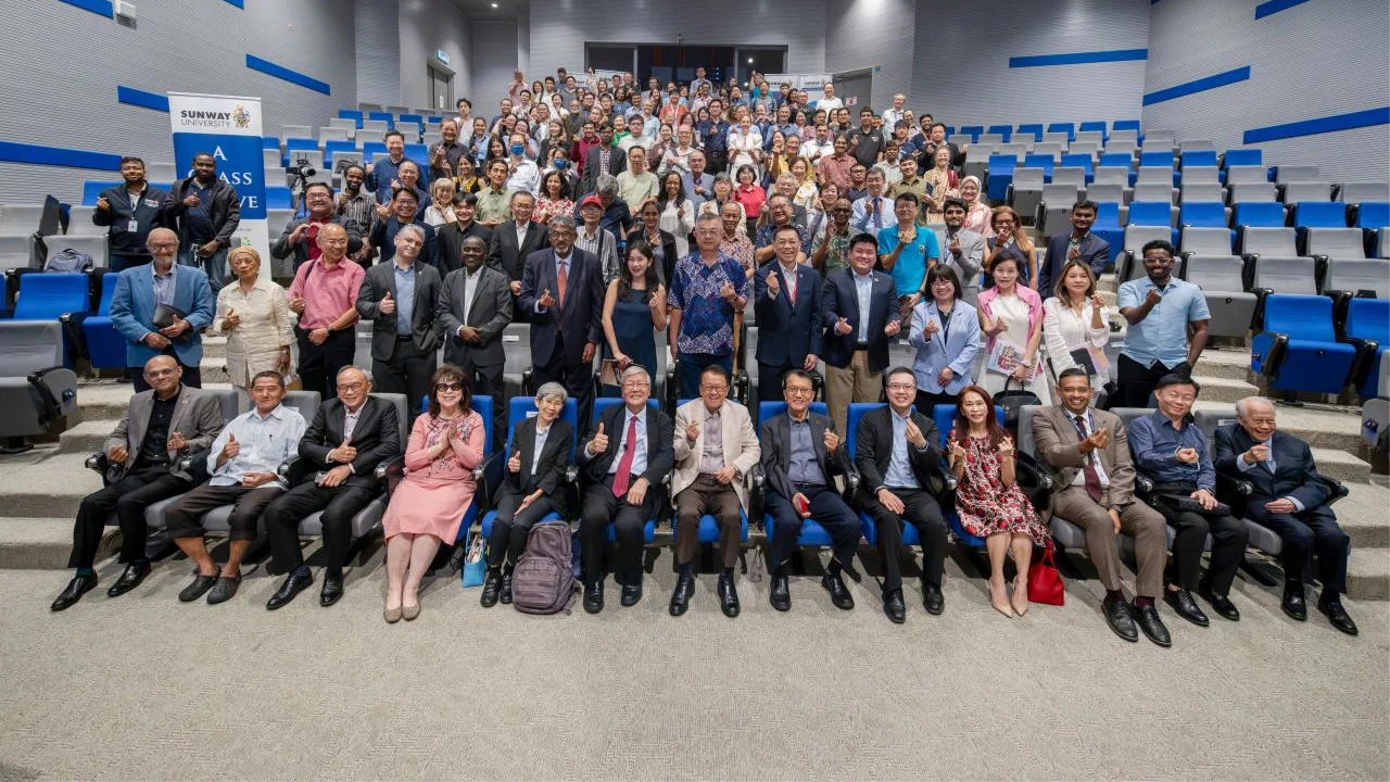 A full lecture theatre audience poses for a group photograph after the speaker series session